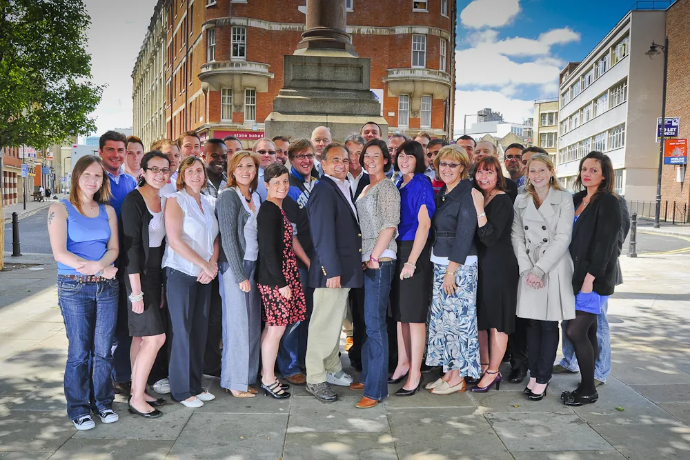 Large team group portrait outside a London office for a B2B publisher, corporate portrait photography by Hector's Eye
