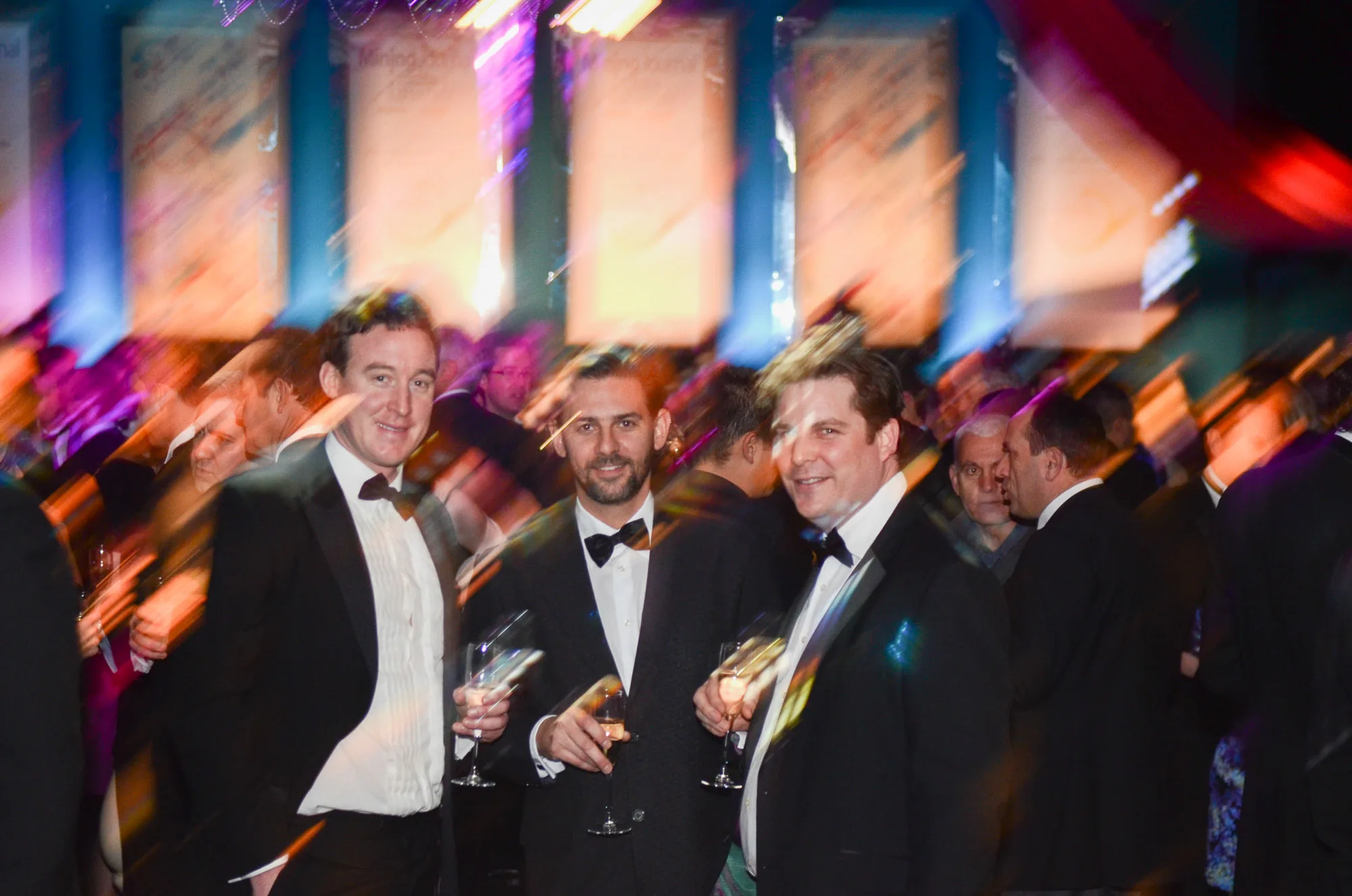 Black-tie guests laughing together at an awards dinner, corporate event photography by Hector's Eye