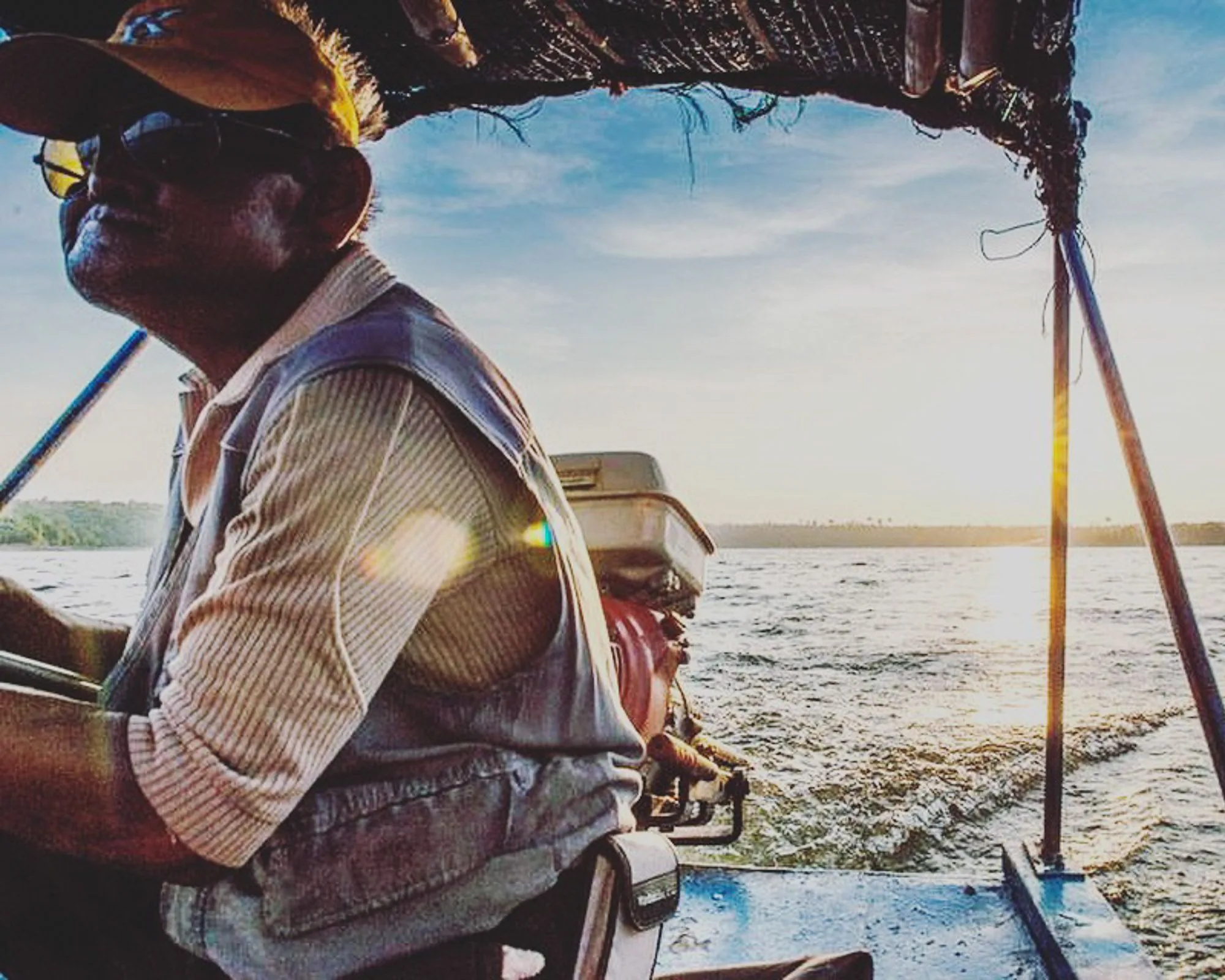 Man at the helm of a small boat on open water, personal photography by Hector's Eye