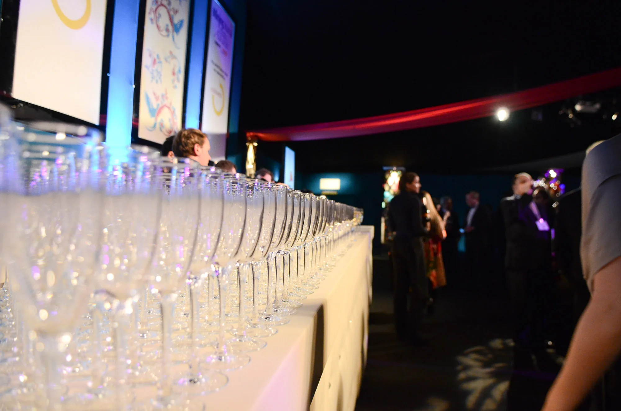 Long row of champagne glasses lined up at an awards dinner reception, corporate event photography by Hector's Eye