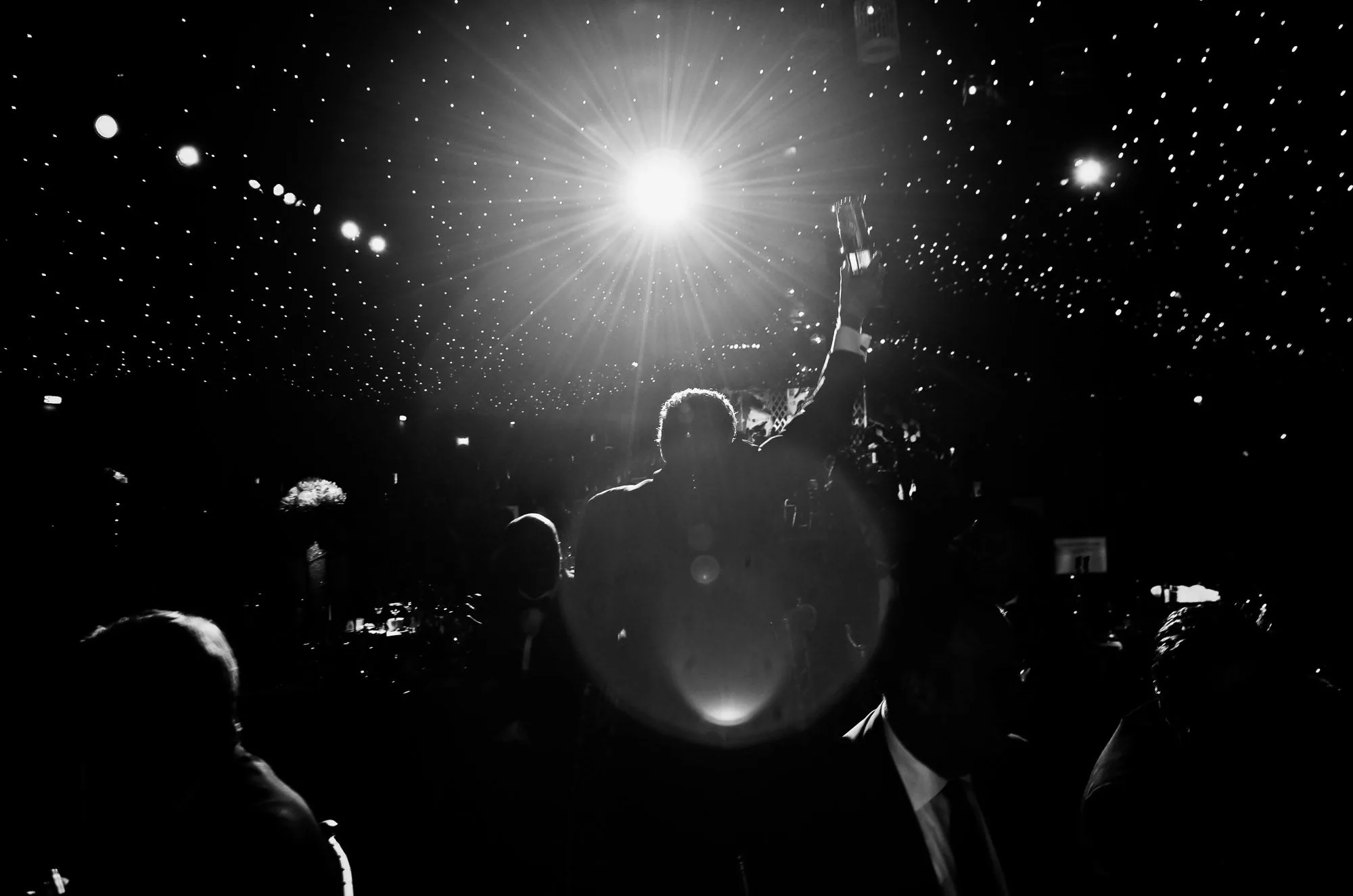 Silhouetted award winner raising a trophy under a starlit ceiling at a corporate awards dinner, event photography by Hector's Eye