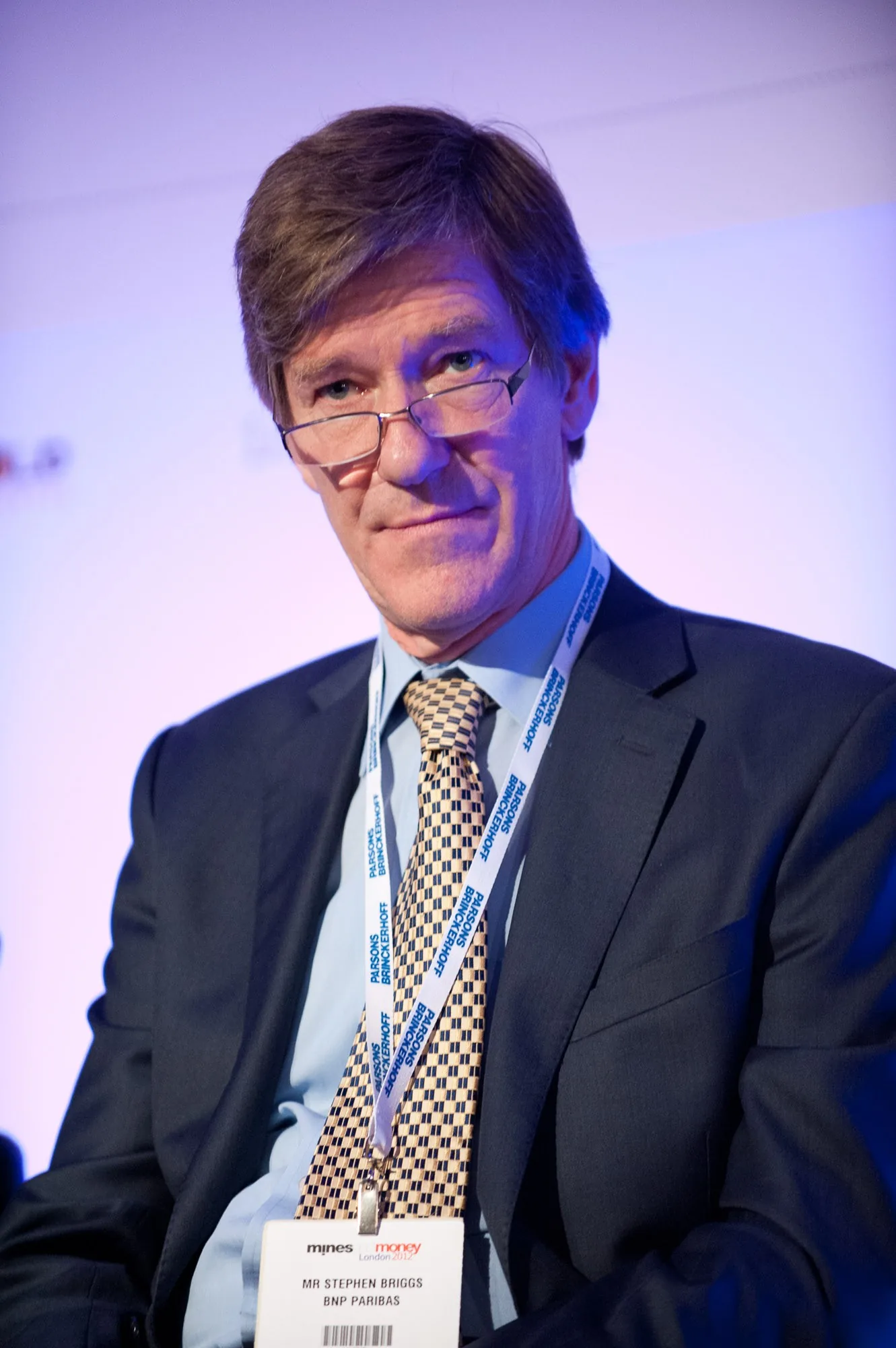 Portrait of a conference delegate wearing glasses and a lanyard badge, corporate event photography by Hector's Eye