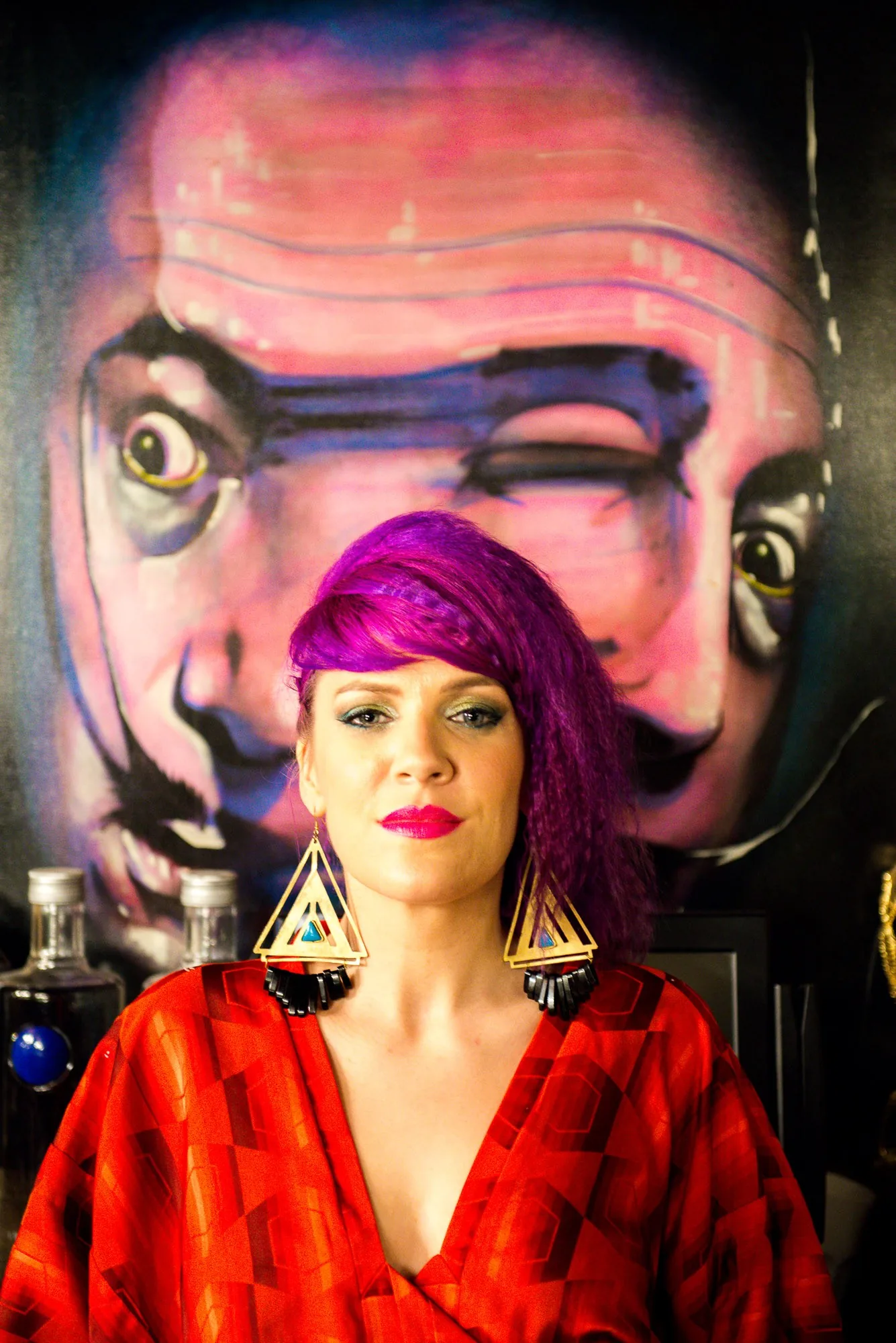 Editorial portrait of a model with pink hair against a surreal painted mural, styled portrait photography by Hector's Eye