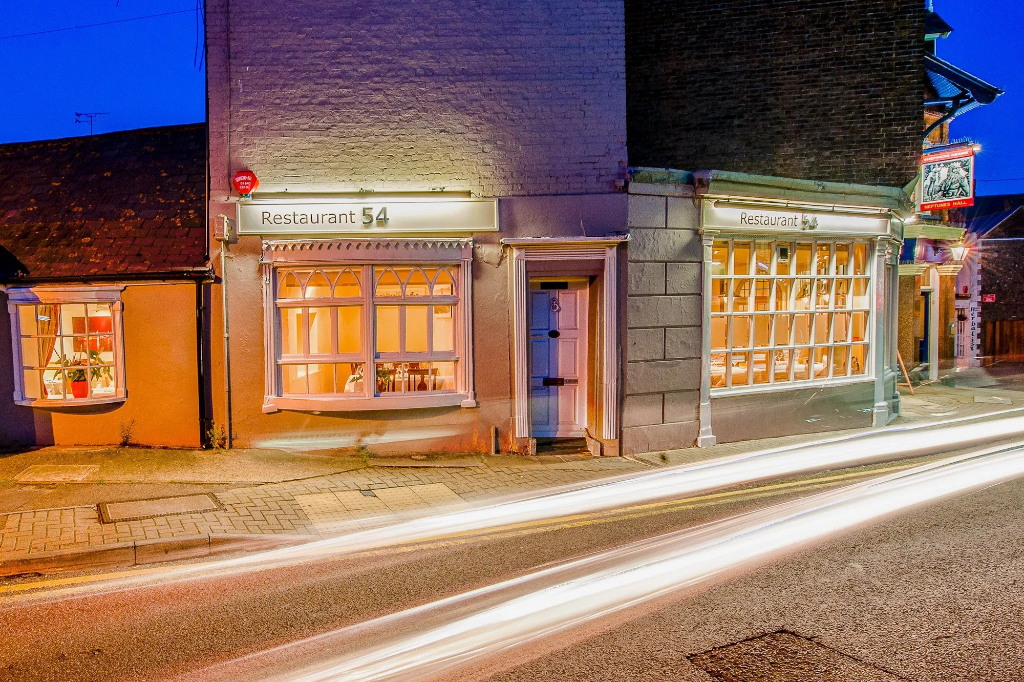 Restaurant exterior at night with light trails from passing traffic, brand storytelling photography by Hector's Eye for Restaurant54