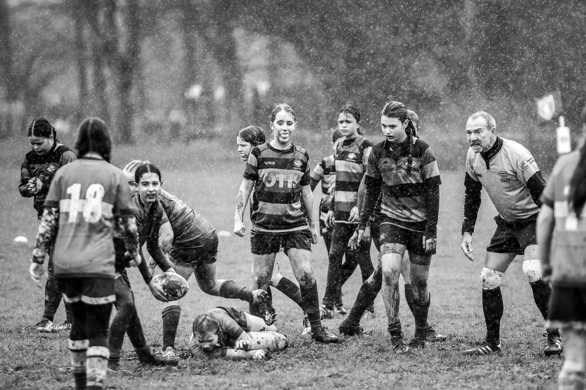 Black and white action shot of a rugby match in the rain, sports photography by Hector's Eye