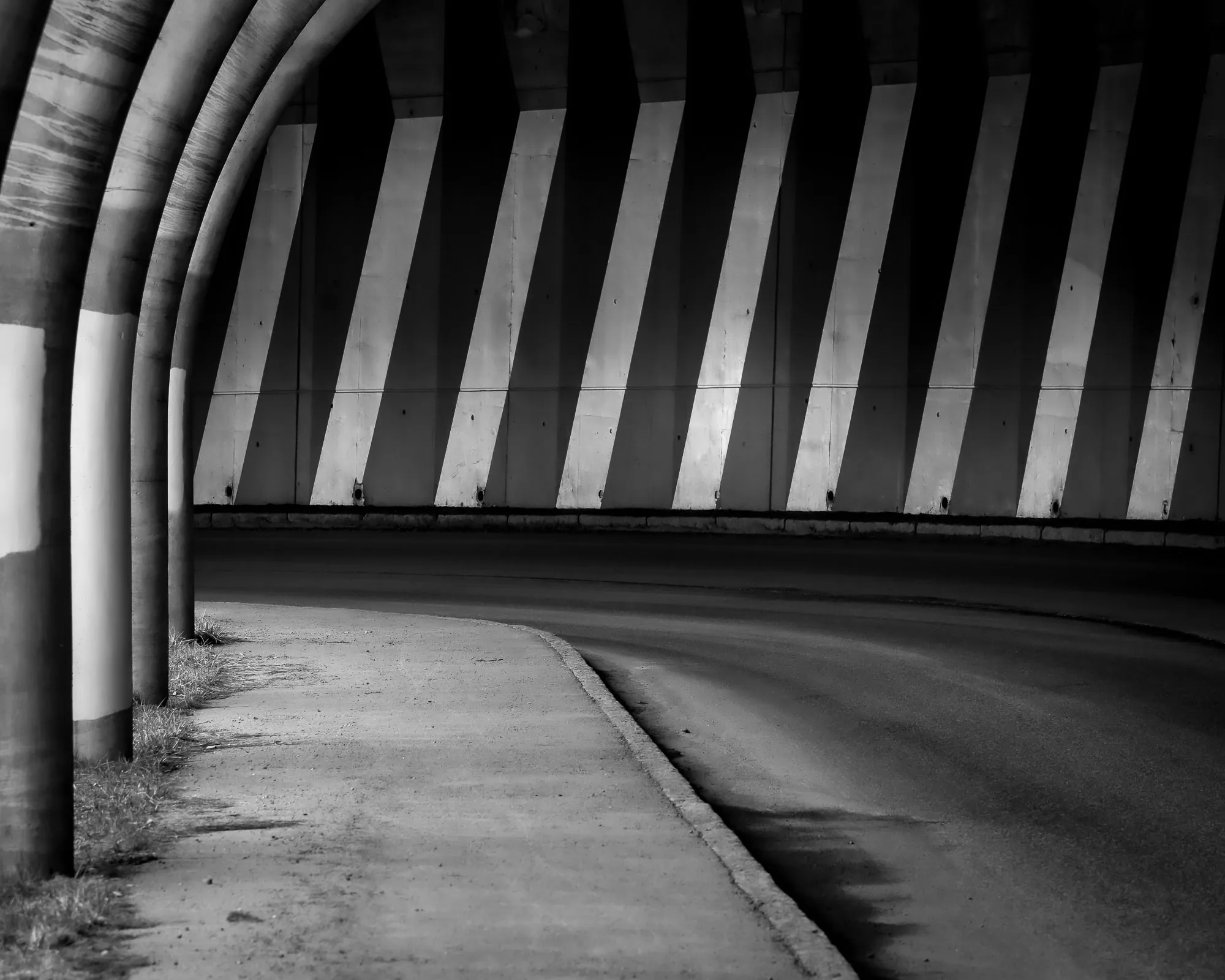 Curving road underpass with striped concrete supports
